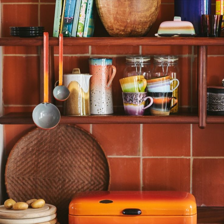 an orange suitcase sitting on top of a counter next to a shelf filled with books