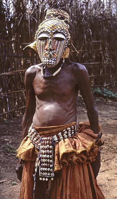 an african man wearing a headdress in front of a fence