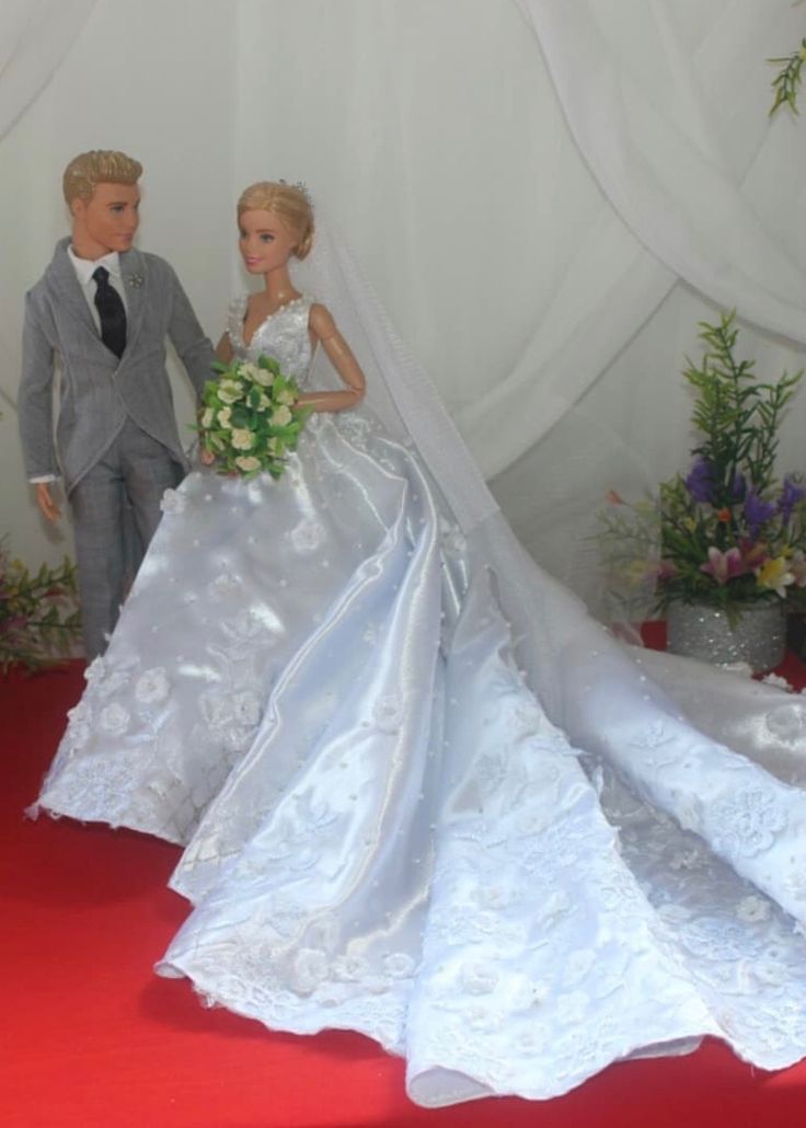 a bride and groom are standing next to each other in front of a red carpet