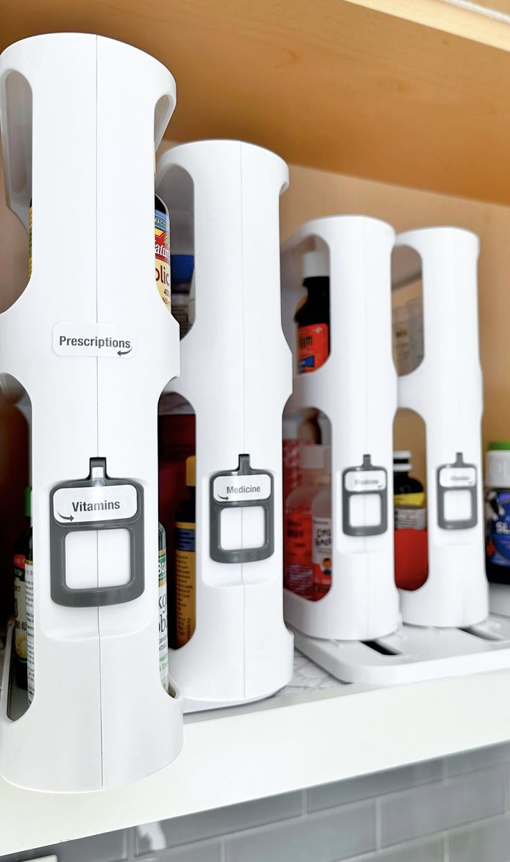 several white kitchen gadgets are lined up on the shelf