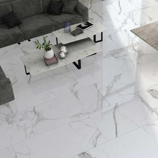 a living room with marble flooring and white walls, grey couches and coffee table