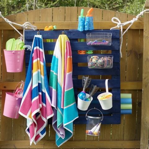 towels, cups and other items are hanging on a fence