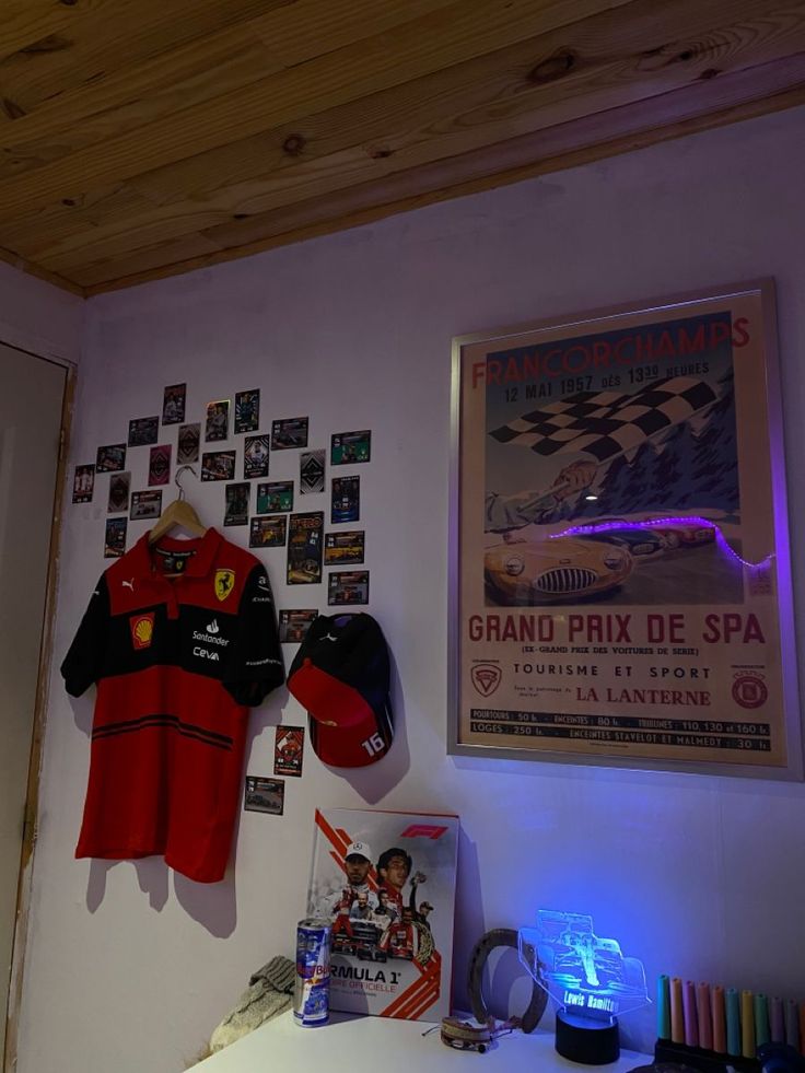 there is a red and black shirt hanging on the wall next to a baseball cap