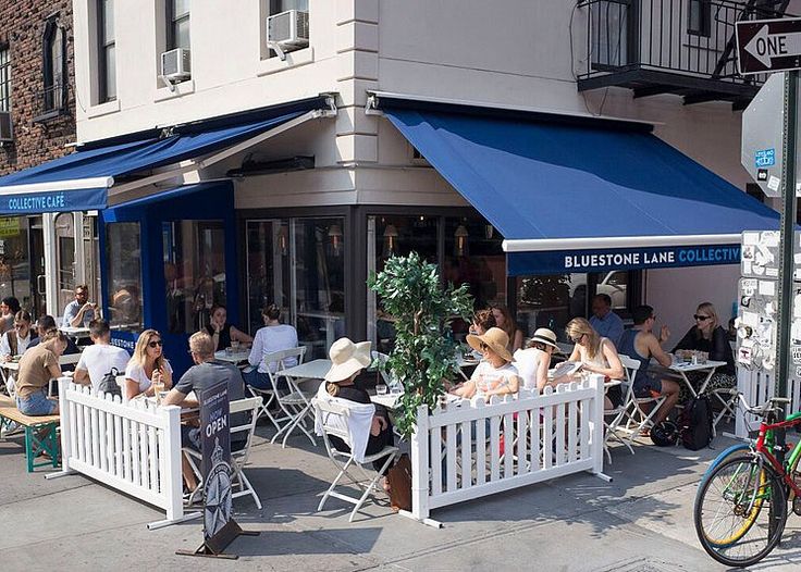 people sitting at tables in front of bluetone lane