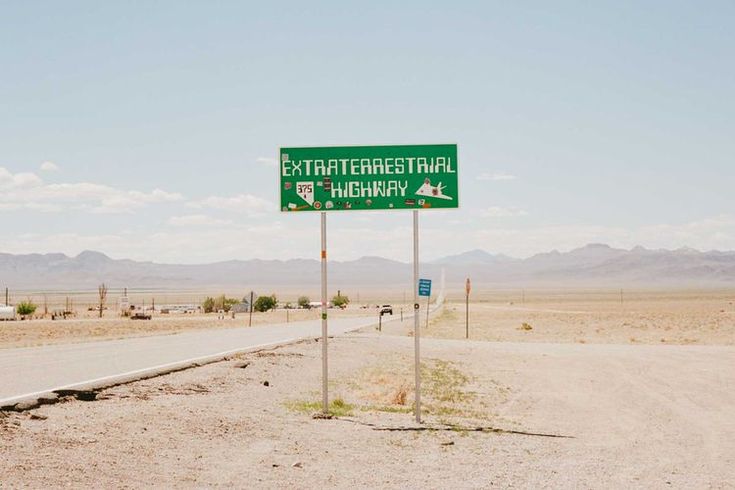 there is a green sign on the side of the road that says extraterrestal highway