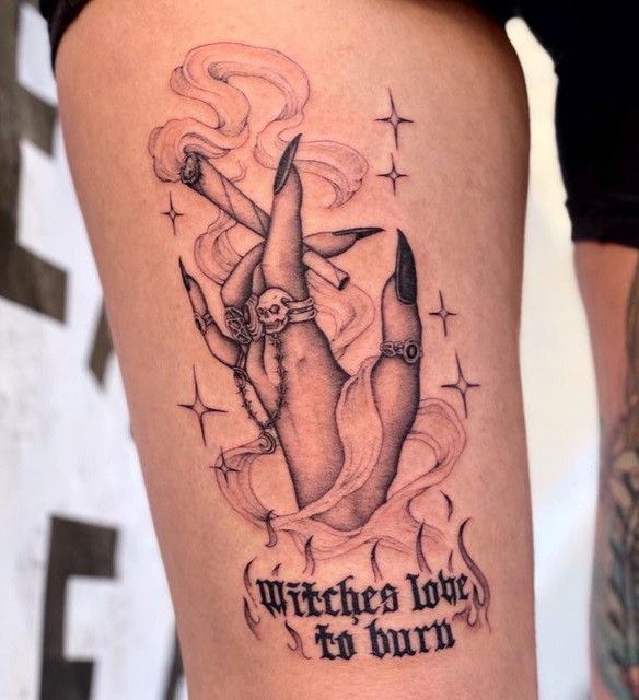 a woman with a tattoo on her thigh that says witch love for burn and an image of a witches foot