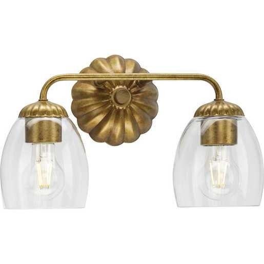 two light bathroom fixture with clear glass shades on the wall and gold metal fittings