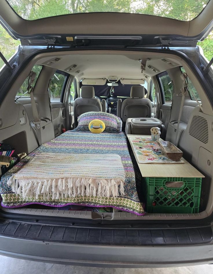 the back end of a van with a bed and two crates in it's trunk