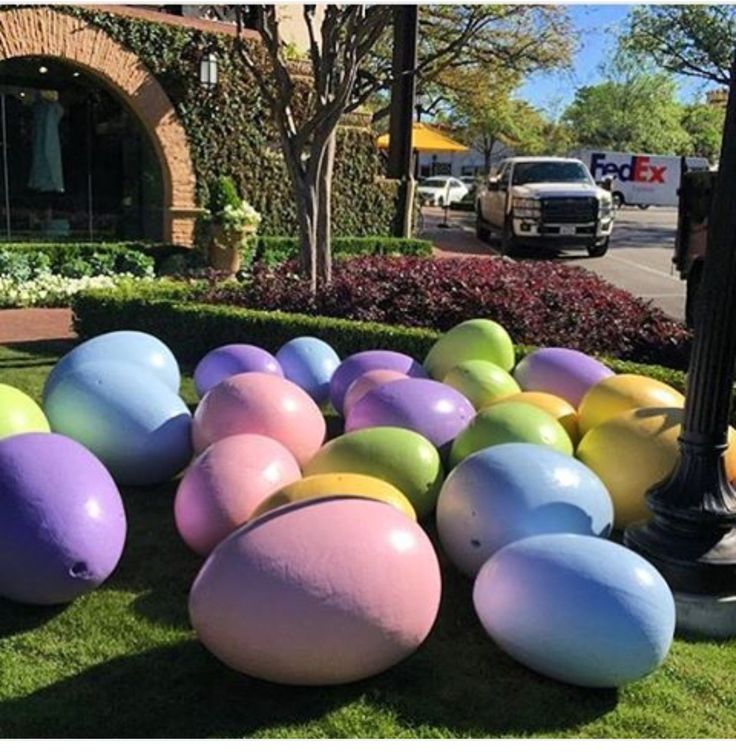 an assortment of large, colorful eggs on the grass in front of a street light