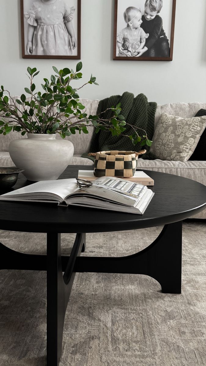 a living room with two pictures on the wall and a coffee table in front of it