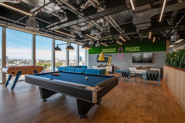 a pool table in a large room with lots of windows