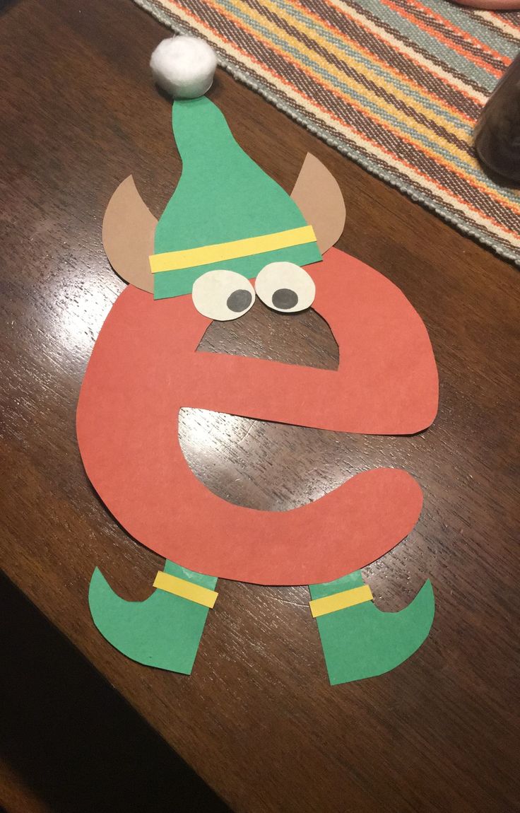 the letter s is made out of paper and has an elf's hat on it