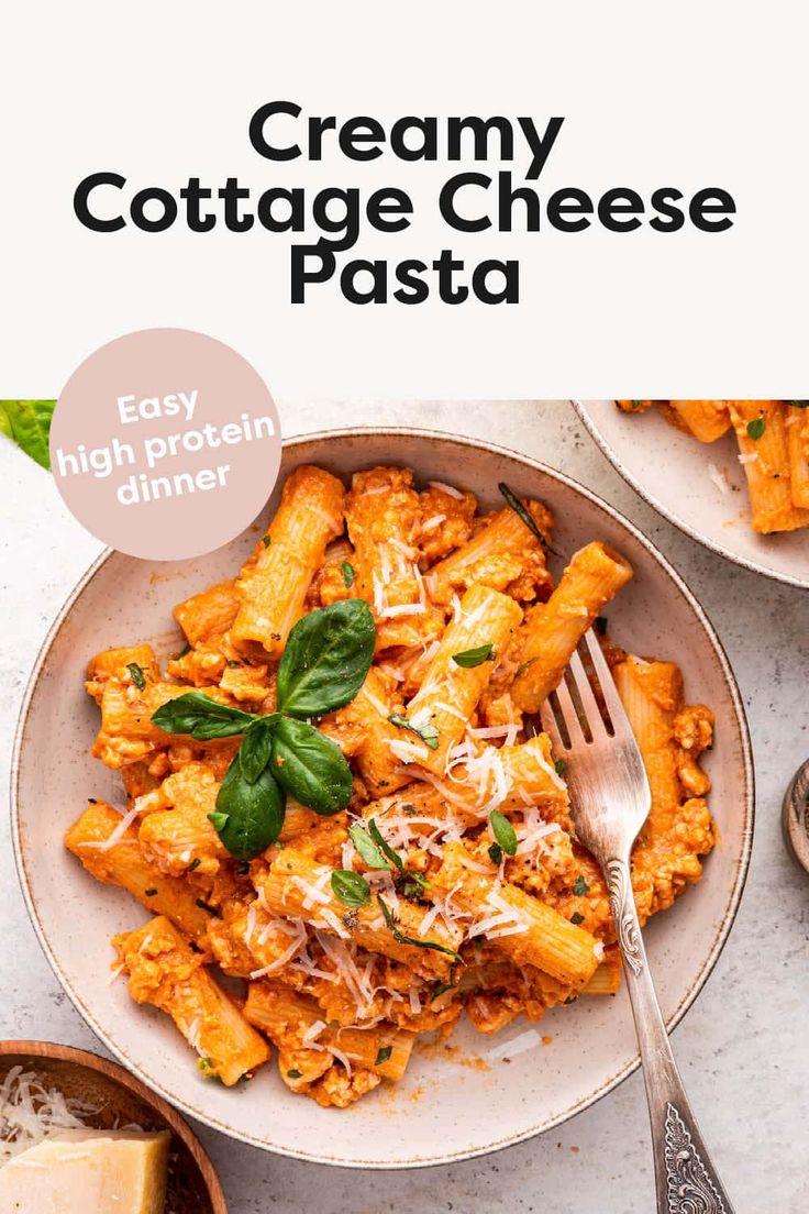 creamy cottage cheese pasta in a white bowl with basil leaves on top and a fork next to it