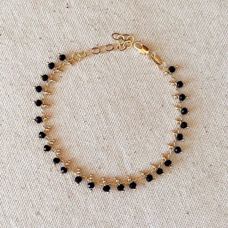 Be captivated by this unique 18k Gold Filled Black Beaded Bracelet. Enjoy its whimsical and fancy design that accentuates your personal style. A perfect and thoughtful gift for yourself or someone special! Have fun with fashion and surprise them with this sophisticated and classic piece. What are you waiting for? 18k Gold Filled Black Beaded Bracelet Metal: 18k Gold Filled Measures 7.25 inches in total length. Weights 4.1 grams Hypoallergenic jewelry - Nickel Free Water-resistant Rigorously manu Affordable Gold Bracelets With Black Beads, Black Bracelets With Tiny Beads For Party, Adjustable Black Bracelets With Gold Beads, Gold Beaded Bracelets As Gift, Trendy Round Beads Chain Bracelet Gift, Trendy Jewelry With Black Round Beads, Dainty Polished Beaded Bracelets As Gift, Elegant Beaded Bracelets With Faceted Beads For Gift, Trendy Gold Beaded Bracelets For Gifts