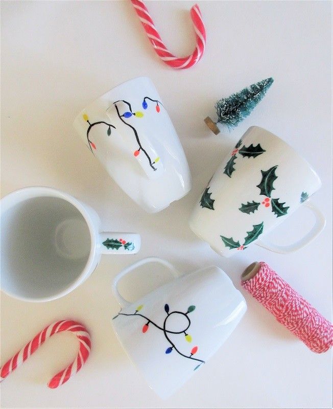 three coffee mugs decorated with christmas designs and candy canes on a white surface