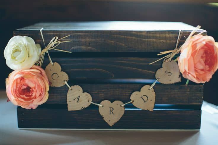 a wooden box with flowers and hearts on it