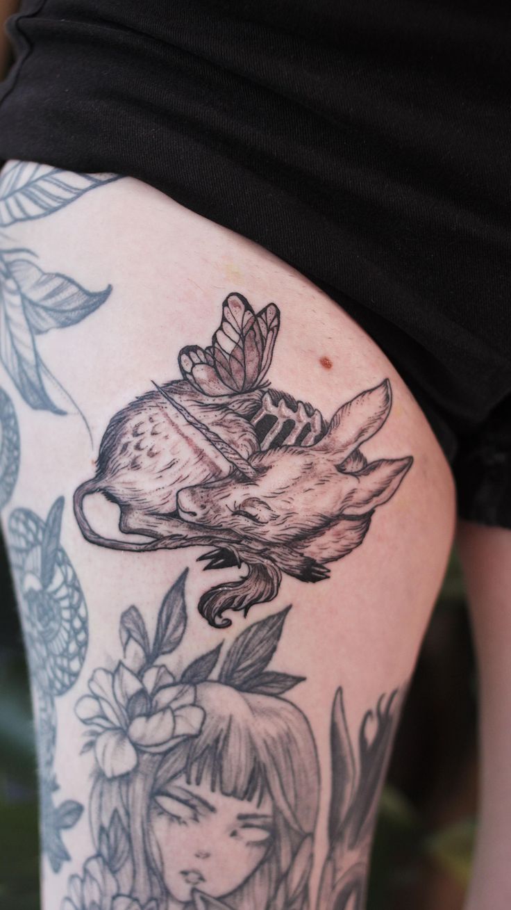 a woman's thigh with tattoos on it