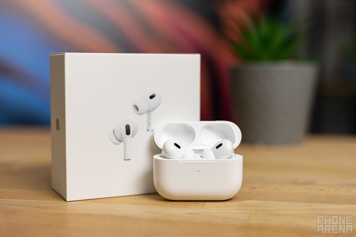 an apple airpods sitting on top of a white box next to a potted plant