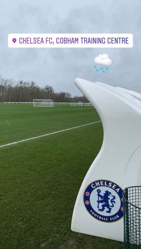 the chelsea f c training centre sign is in front of a soccer field with grass