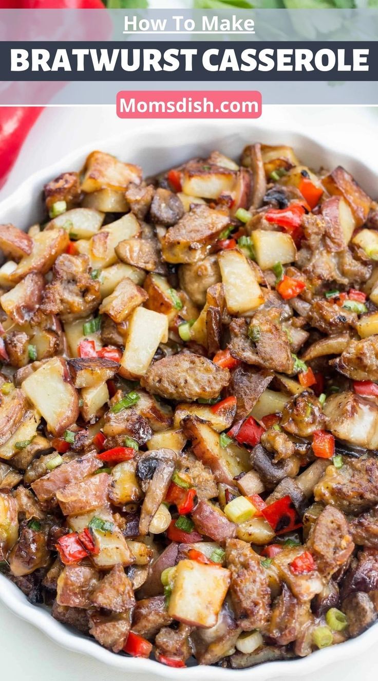 a white bowl filled with meat and vegetables on top of a table next to peppers