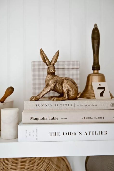 the books are stacked on top of each other with a gold rabbit statue next to them