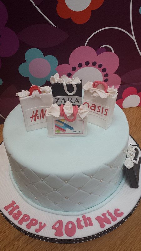 a birthday cake with shopping bags on top