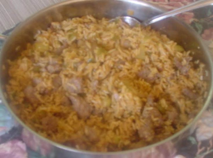 a large metal pan filled with food on top of a floral table cloth next to utensils