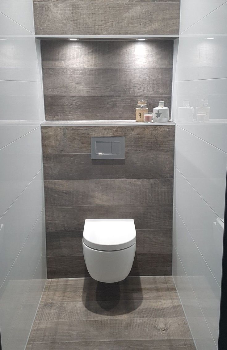 a white toilet sitting inside of a bathroom next to a wall mounted shelf filled with items