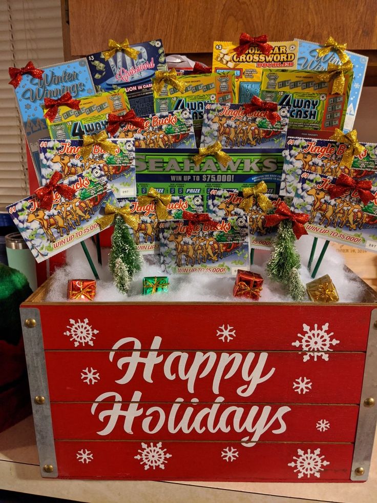 a red box filled with candy sitting on top of a wooden table covered in snow