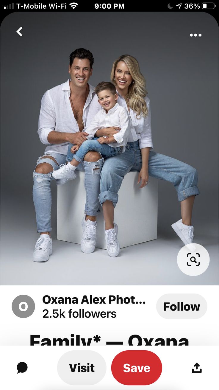 a man and woman sitting on top of a white box holding a small child in their lap