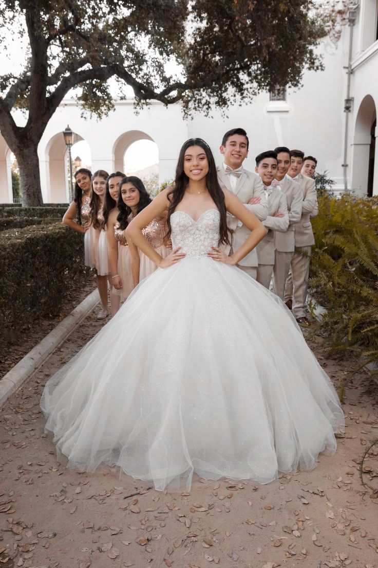 a bride and groom posing for a photo with their bridal party in the background