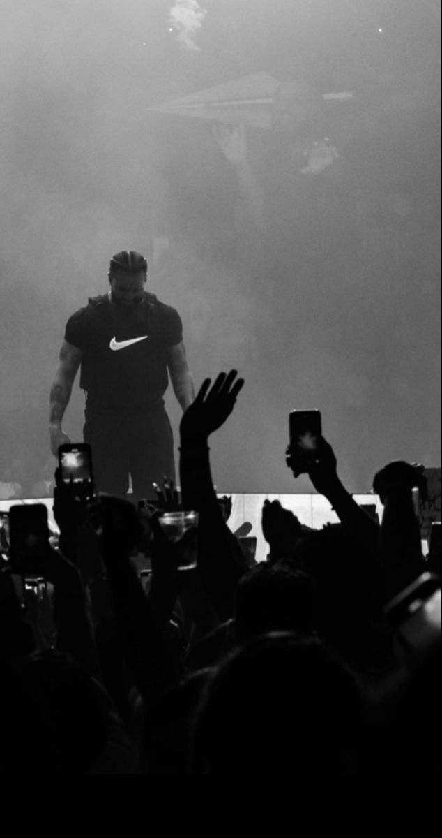 a man standing on top of a stage with his hands up in front of him