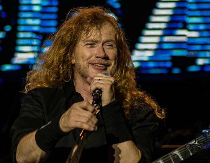 a man with long hair holding a microphone