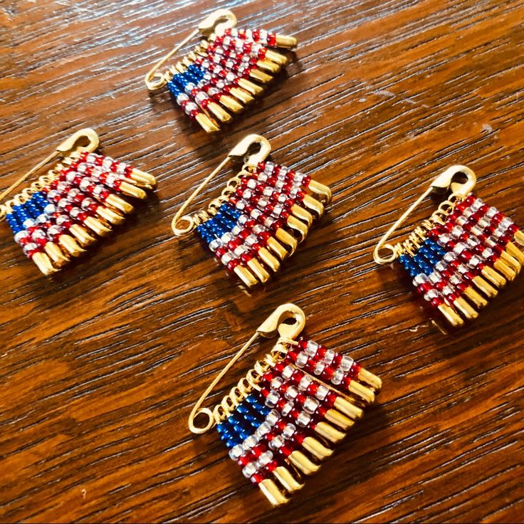 four small red, white and blue hair clips on a wooden table