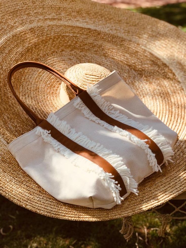 two straw bags sitting on top of a hat