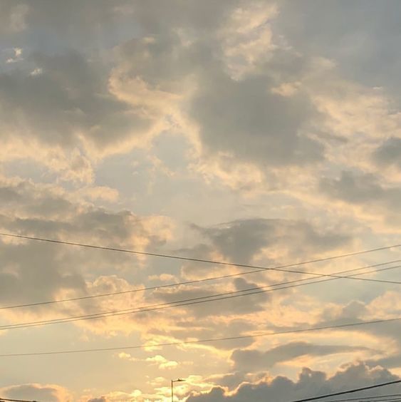 the sky is filled with clouds and power lines