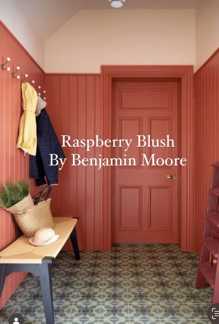 a hallway with red walls and a bench in front of the door that says raspberry blush by benjamin moore