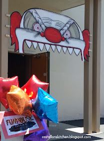 balloons are in front of a building with a clown's head painted on it