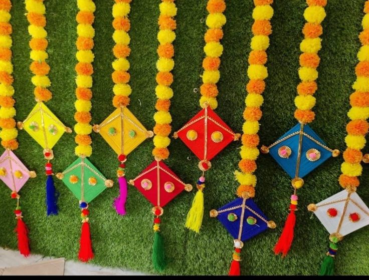 colorful kites are hanging on the grass with tassels attached to each one