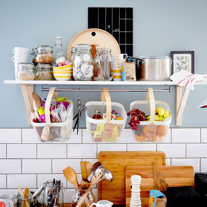 the shelves above the kitchen counter are filled with dishes and utensils, including bread