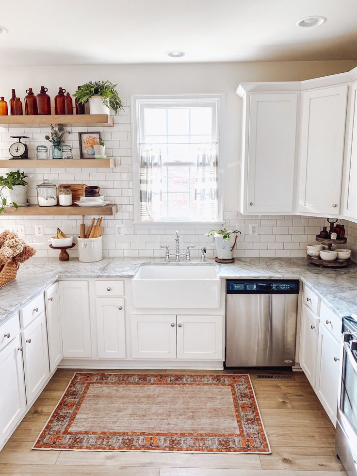 a clean kitchen with white cabinets and stainless steel dishwasher in the center area