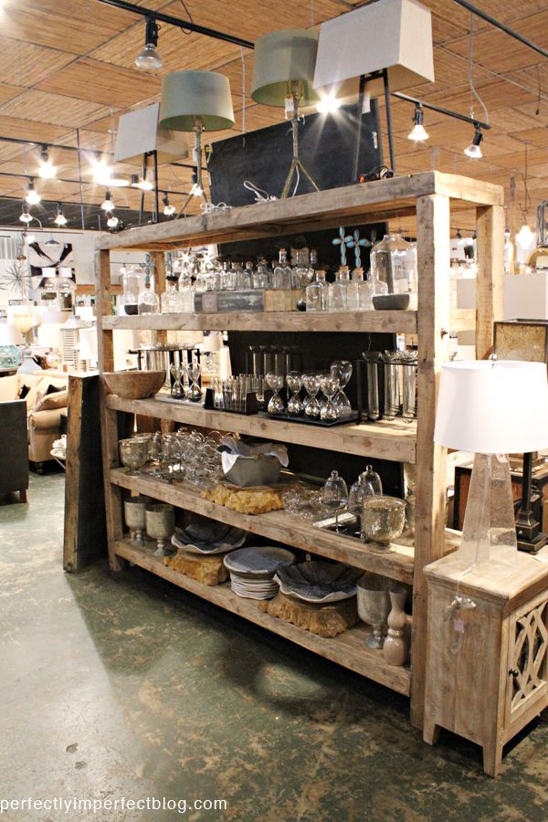 a store filled with lots of glassware and other items on shelves next to lamps