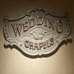 a metal sign that says wedding chapel on the side of a wall in a room