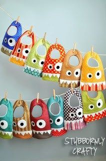 baby bibs hanging on a clothes line with eyeballs and polka dots in different colors