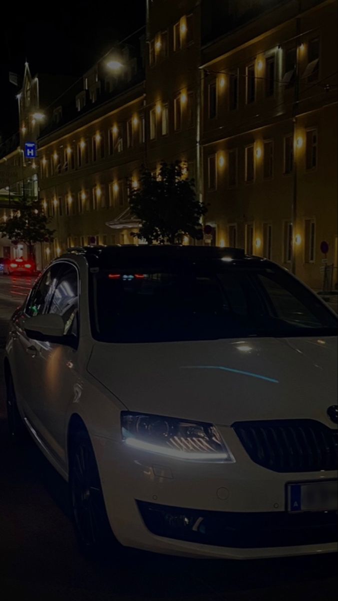 cars are parked on the street at night