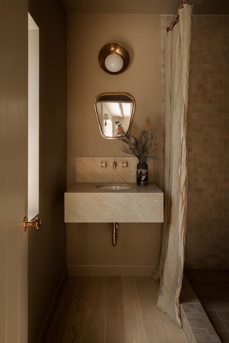 a bathroom with a sink, mirror and shower curtain in it's center area