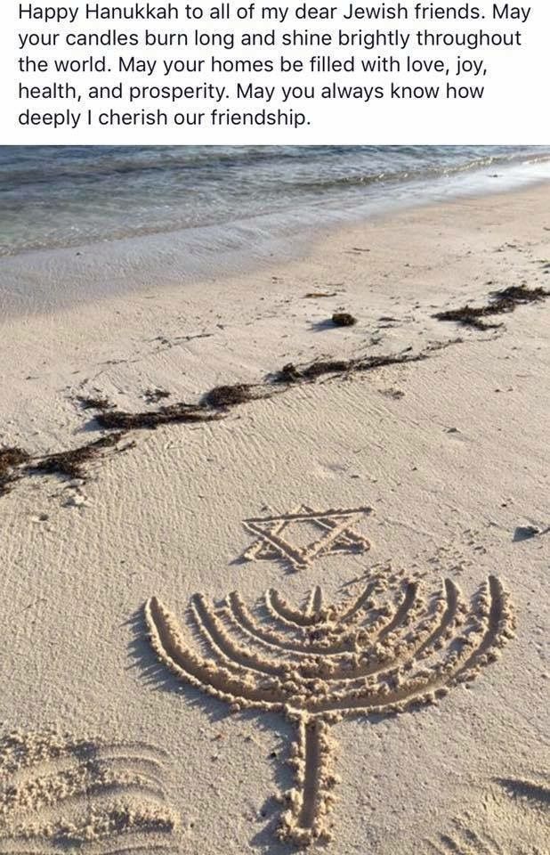 a menorah drawn in the sand at the beach with words written on it