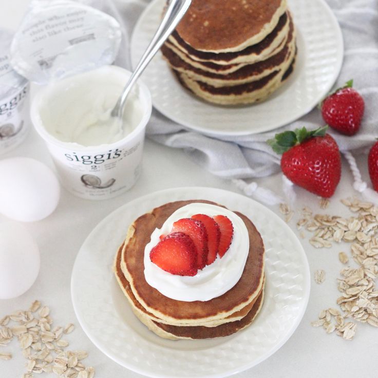 pancakes with whipped cream and strawberries on plates