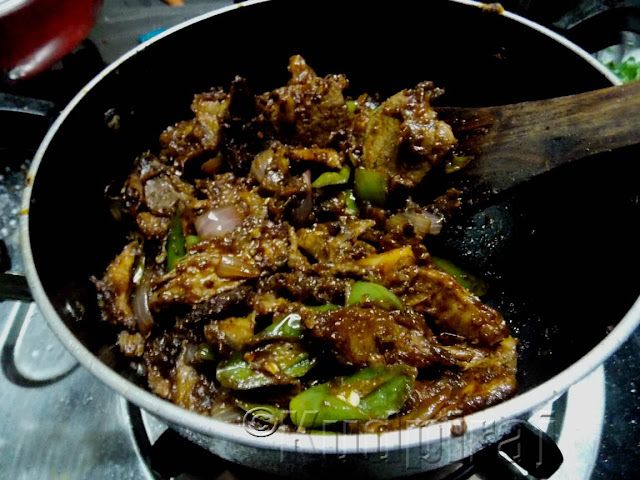 the food is being cooked in the pan on the stove top with a wooden spoon