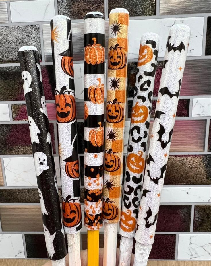 halloween themed pens are lined up in a cup